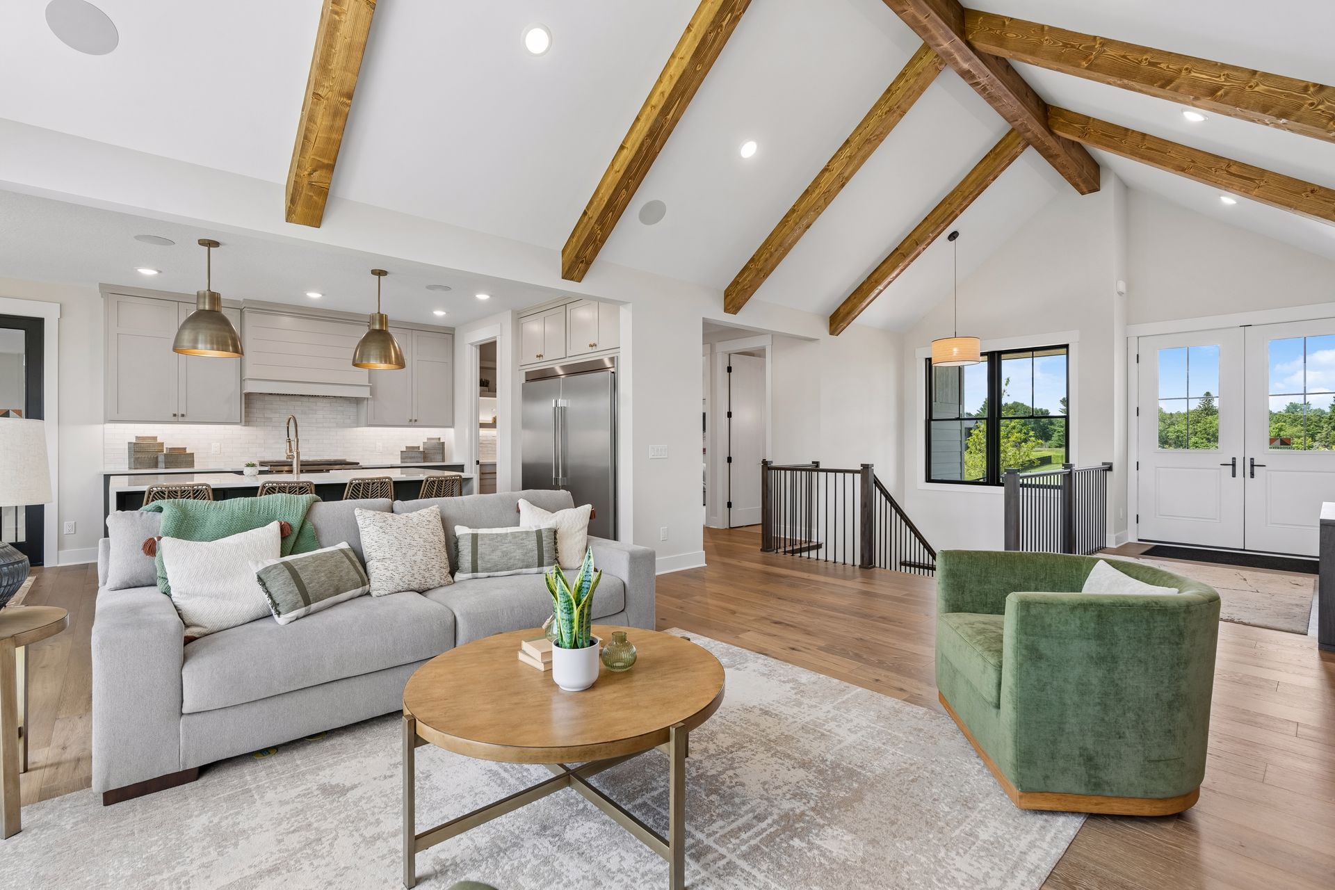 Open concept great room and gourmet kitchen with exposed wood beams